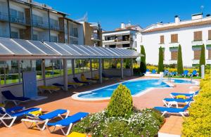 un complexe avec une piscine et des chaises longues dans l'établissement Hotel Port-Bo, à Calella de Palafrugell