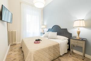 - une chambre avec un grand lit et une télévision dans l'établissement Altarocca Embassy Rome, à Rome