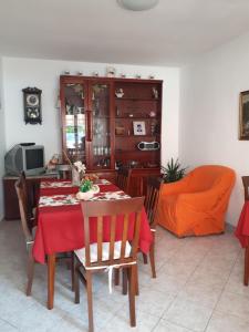 een eetkamer met een rode tafel en stoelen bij Guest house Maria Rosa in Rab