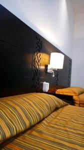 a hotel room with a bed and a lamp at Aparthotel Siete 32 in Mérida