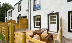 a wooden deck with a bench in front of a house at Waterfoot Park in Pooley Bridge +101 photos