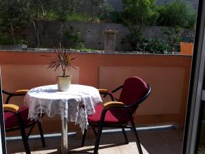 een tafel en stoelen op een terras bij Guest house Maria Rosa in Rab