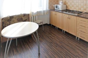 a kitchen with a white table and a microwave at Apartments on Tsentralnaya Ploshad in Kaliningrad