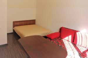カリーニングラードにあるApartments on Tsentralnaya Ploshadのベッド1台とソファが備わる小さな客室です。