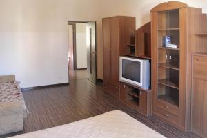 a room with a bed and a tv and wooden cabinets at Apartments on Tsentralnaya Ploshad in Kaliningrad