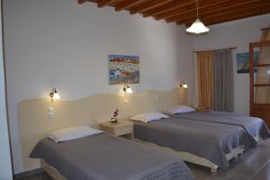 two beds in a hotel room with two beds at Studios Flora Manos in Platis Gialos