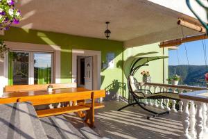 a porch with a wooden table and a bench at Apartman Stela Gornje Sitno in Split