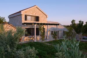 a stone house with a window in a yard at Holiday House KALIMERO in Primošten +4 photos