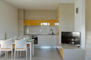 a kitchen with a table and chairs and a television at Holiday House KALIMERO in Primošten