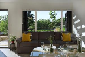 a living room with a couch and tables with yellow pillows at Holiday House KALIMERO in Primošten