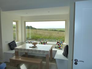 a dining room with a table and a large window at Mary's Meadow in Doolin