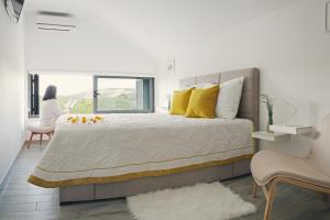 a bedroom with a large bed and a woman looking out the window at Holiday House KALIMERO in Primošten