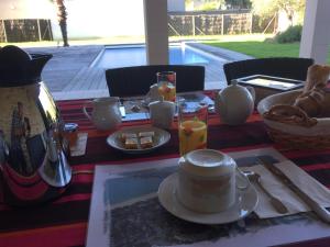 uma mesa com um prato de comida e um bule de chá em L'océane em Le Pouliguen