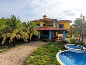 una casa con piscina frente a ella en Solyar Luxury Spanish Beachfront Home en Pochomil