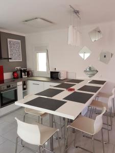 cocina con mesa y sillas en blanco y negro en penthouse Llancia, en Llançà