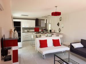 sala de estar con sofá blanco y almohadas rojas en penthouse Llancia, en Llançà