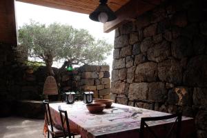 a table in a room with a stone wall at Dammuso Il Sogno in Scauri +29 photos