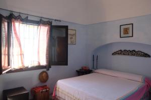 a bedroom with a bed and a window at Dammuso Il Sogno in Scauri