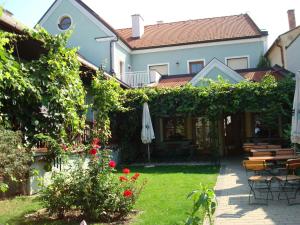 a garden with an umbrella and a table and chairs at Beim Gangl in Illmitz