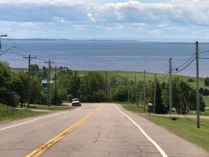 an empty road with a car driving down the road at Seaview White House in Stratford