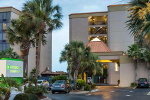 a parking lot in front of a hotel with palm trees at Wyndham Garden Fort Walton Beach Destin in Fort Walton Beach