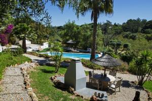 un complexe avec une piscine, une table et des chaises dans l'établissement Casa Sereno, à Benagil