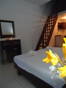 a bedroom with a bed and a staircase with yellow flowers at Hotel Zachos in Troulos