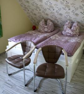 カロリーネンジールにあるFewo-Wattstuermerの- 椅子2脚、ベッドルーム1室