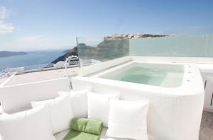 uma banheira de hidromassagem numa varanda com o oceano em Allure Suites em Firostefani