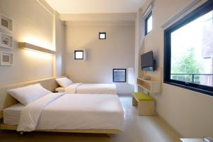 a hotel room with two beds and a window at Arjuna Hotel Batu City in Batu