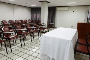 uma sala de conferências com cadeiras, uma mesa e um pódio em Livramento Palace Hotel em Vitória da Conquista