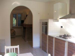 a kitchen with an archway leading into a room at La casetta di Sofia in Moneglia