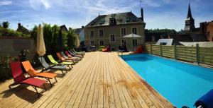 a wooden deck with chairs and a swimming pool at l'Escale de Broglie in Broglie