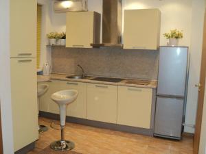 a kitchen with white cabinets and a sink and a refrigerator at Guest House Valentino in Krasnodar