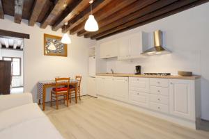 a kitchen with white cabinets and a table with chairs at Ca RIZZI in Venice