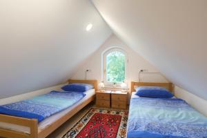 two beds in a attic bedroom with a window at Vila Katja in Bled