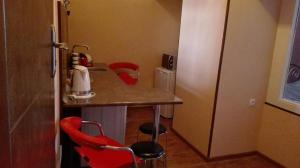 a small kitchen with a counter and two red chairs at Apartment in the heart of Old Tbilisi in Tbilisi City