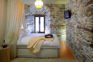 a bedroom with a bed in a stone wall at Mountain's Secret in Mouresi