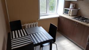 サマラにあるАппартаменты на Воронежскойのキッチン(テーブル、椅子、電子レンジ付)