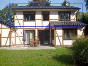 una casa con sombrilla, mesa y sillas en Ferienwohnung-Draeger, en Mardorf