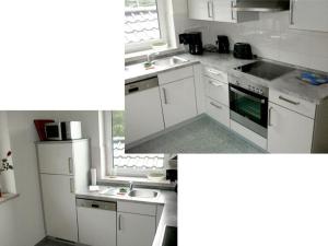 a kitchen with white cabinets and a sink and a window at Ferienwohnung-Draeger in Mardorf