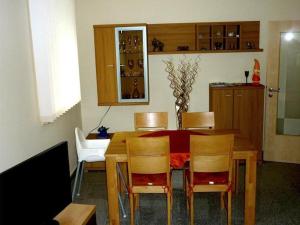 comedor con mesa de madera y sillas en Ferienwohnung-Draeger, en Mardorf