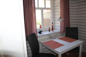 a dining room table with two chairs and a window at Ferienwohnung-Abendroete in Lüdersburg