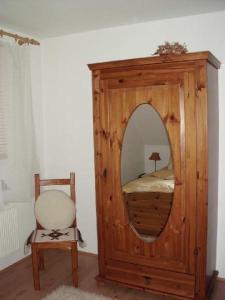 een spiegel in een kamer met een stoel en een bed bij Ferienwohnung-Mund in Pillnitz