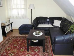 a living room with a black leather couch and a table at Ferienwohnung-Mund in Pillnitz
