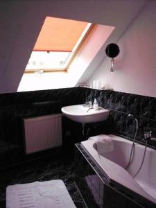 La salle de bains est pourvue d'un lavabo, d'une baignoire et d'une lucarne. dans l'établissement Ferienwohnung-Mund, à Pillnitz