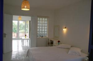 una camera bianca con un letto e una finestra di Handrina Studios a Naxos Chora
