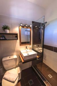 a bathroom with a toilet and a sink and a mirror at Aliston Hotel Thassos in Skala Potamias