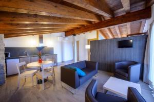 a living room with a blue couch and a table at Mas Pere Pau in Besalú