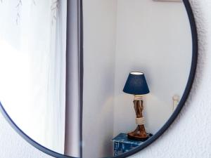 ein Spiegel mit einer Lampe auf einem Tisch in einem Zimmer in der Unterkunft Blue Era Apartments in Batsi